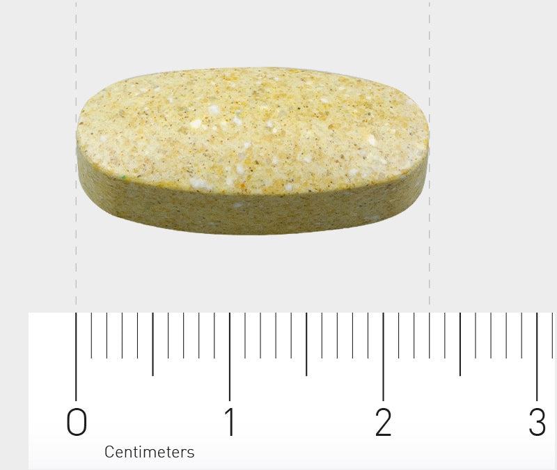 Eine ovale, beige Tablette liegt auf einer weißen Oberfläche. Unter der Tablette ist ein Lineal mit Zentimeterangaben zu sehen, das die Größe der Tablette veranschaulicht. Die Tablette ist etwa 2 Zentimeter lang.