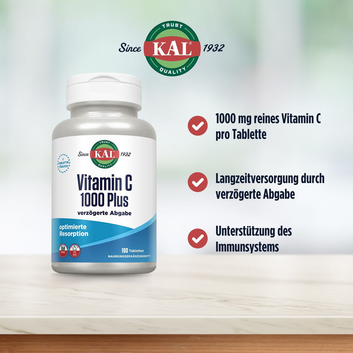 Eine Flasche des Nahrungsergänzungsmittels KAL Vitamin C 1000 Plus steht auf einem Tisch. Neben der Flasche sind drei Checklistenpunkte abgebildet: 1000 mg reines Vitamin C pro Tablette, Langzeitversorgung durch verzögerte Abgabe, Unterstützung des Immunsystems. Der Hintergrund ist unscharf und grünlich. Oben links ist das KAL-Logo mit dem Text 'Since 1932' zu sehen.