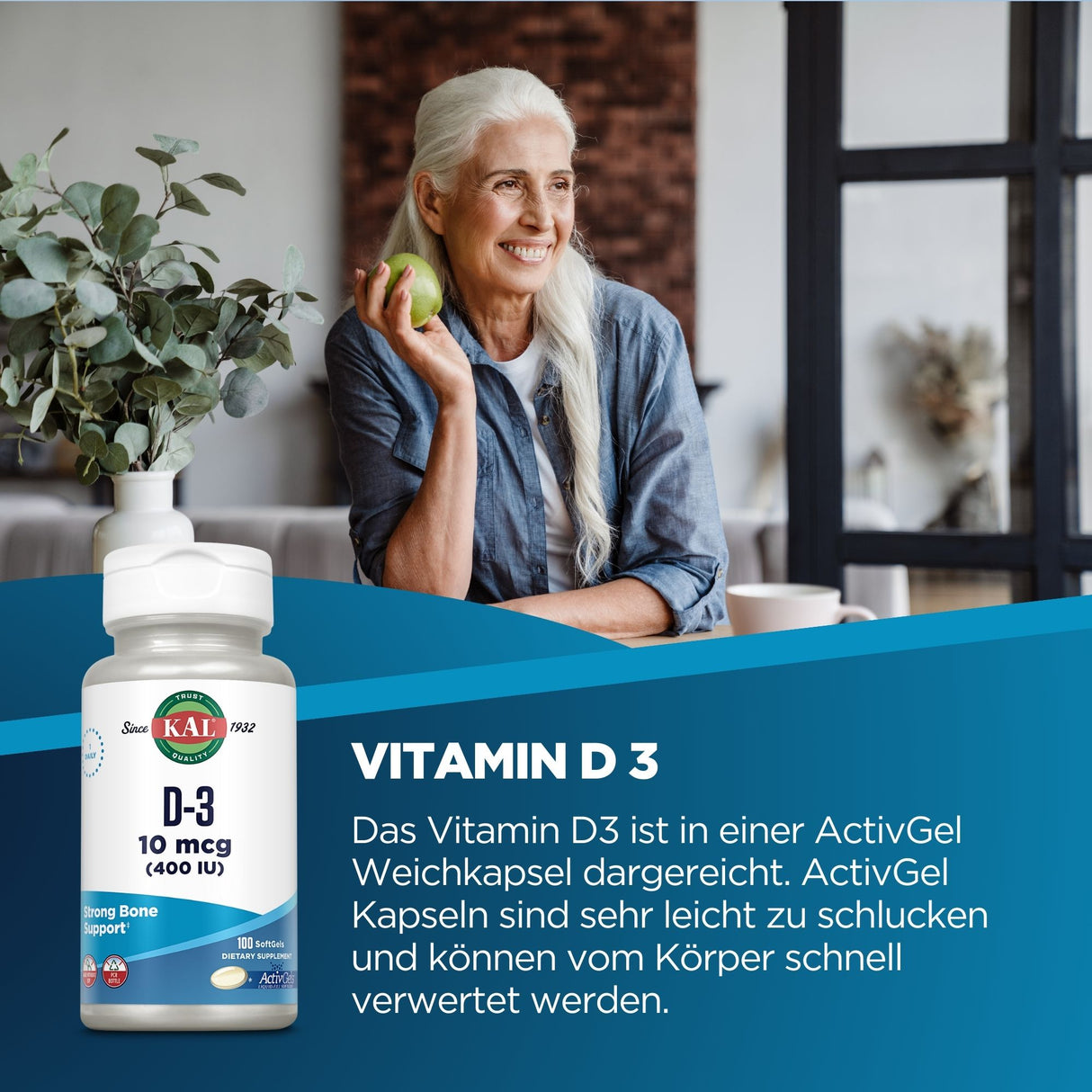 Eine ältere Frau mit langen weißen Haaren sitzt an einem Tisch, hält einen grünen Apfel und lächelt. Neben ihr steht eine Pflanze in einem weißen Topf. Im Vordergrund ist eine Verpackung von Vitamin D3 Weichkapseln der Marke KAL zu sehen, mit Text über die Vorteile der Kapseln.