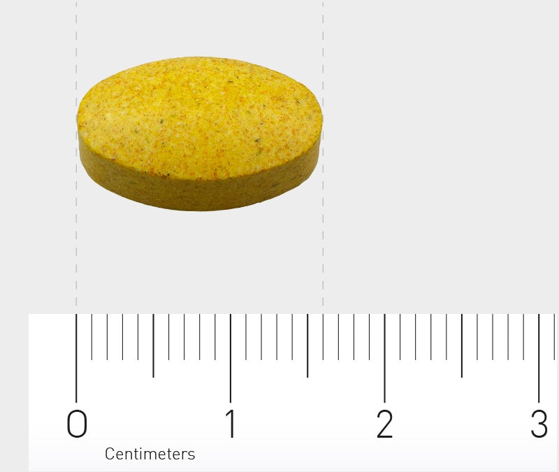 Eine gelbe, ovale Tablette liegt auf einem Lineal, das in Zentimetern skaliert ist. Die Tablette misst etwa 1,5 Zentimeter in der Länge. Der Hintergrund ist neutral grau.