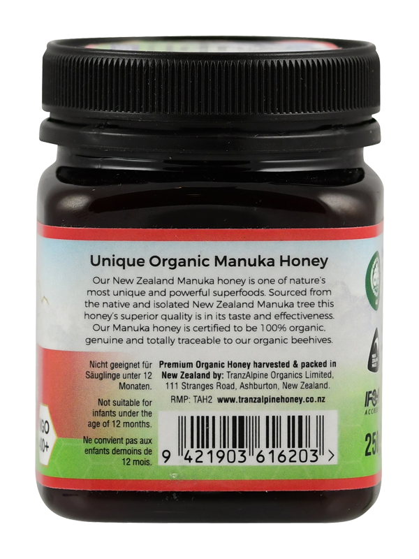 Ein Glas mit schwarzem Deckel, das "Unique Organic Manuka Honey" enthält. Das Etikett beschreibt den Honig als einzigartig und kraftvoll, gewonnen aus neuseeländischen Manuka-Bäumen. Er ist 100% organisch und rückverfolgbar zu den Bienenstöcken. Das Glas hat einen Barcode und die Adresse des Herstellers in Ashburton, Neuseeland.