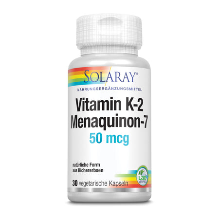 Eine weiße Plastikflasche mit einem farbigen Etikett, das "SOLARAY Vitamin K-2 Menaquinon-7 50 mcg" anzeigt. Die Flasche enthält 30 vegetarische Kapseln und ist als Nahrungsergänzungsmittel aus natürlicher Form von Kichererbsen gekennzeichnet. Ein Lab Verified-Siegel befindet sich auf dem Etikett.