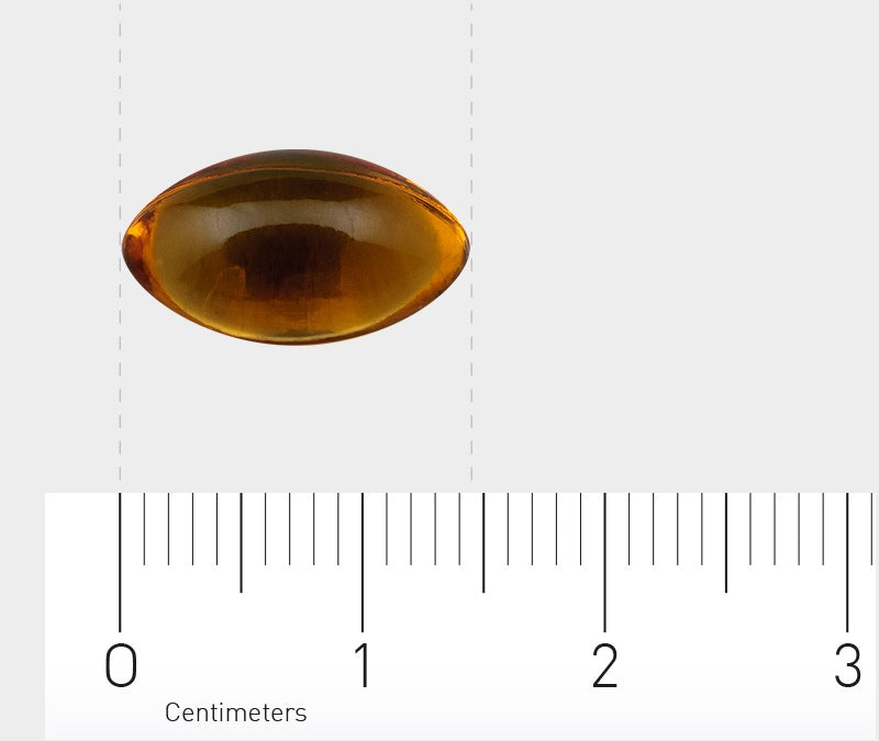 Eine gelbe, ovale Gelkapsel liegt auf einer weißen Oberfläche mit einem Lineal darunter. Das Lineal zeigt Zentimetermaße an, wobei die Kapsel etwa 2 cm lang ist.