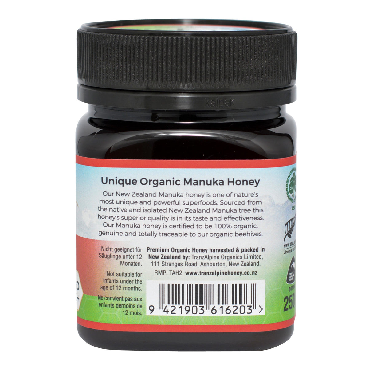 Ein Glas mit schwarzem Deckel, das Manuka-Honig enthält. Auf dem Etikett steht "Unique Organic Manuka Honey". Der Honig stammt aus Neuseeland und wird von TranzAlpine Organics Limited hergestellt. Das Etikett enthält Informationen zur Herkunft und Qualität des Honigs sowie einen Barcode.