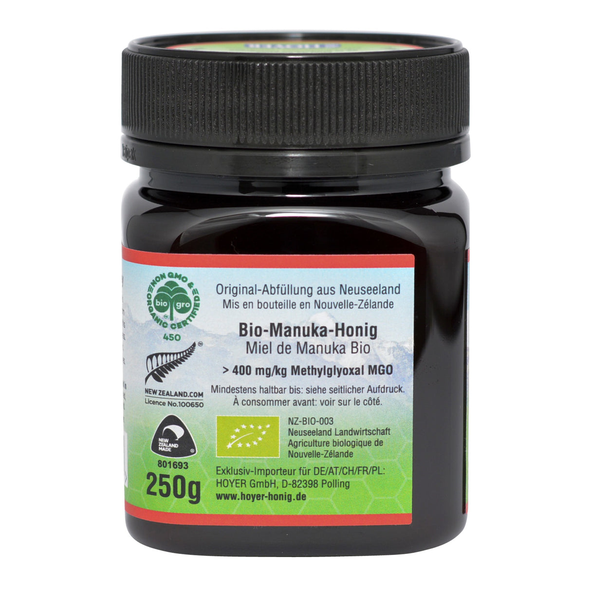 Das Bild zeigt ein Glas Bio-Manuka-Honig, abgefüllt in Neuseeland. Auf dem Etikett sind Informationen wie der MGO-Gehalt von über 400 mg/kg, Bio-Zertifizierungen und der Importeur Hoyer GmbH zu sehen. Das Glas hat ein schwarzes Schraubdeckel und fasst 250g.