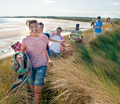 Ausflug zum Strand - Gruppe von junge Menschen auf dem Weg durch die Dünen