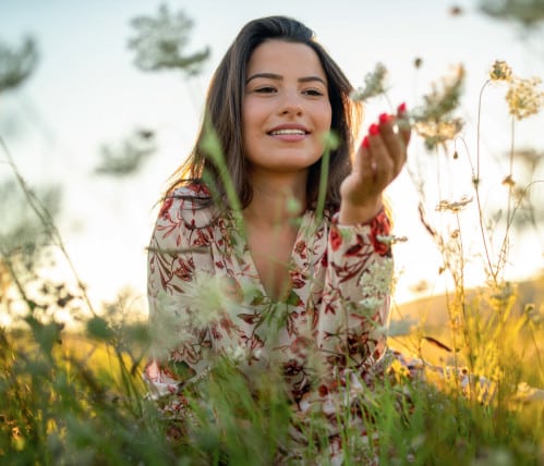 junge-frau-mit-farbenfroher-sommerkleidung-auf-blumenwiese