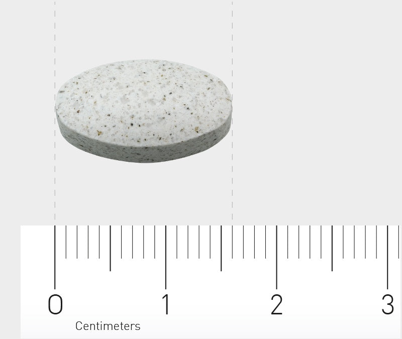 Ein einzelnes, ovales, graues Tablett auf einem weißen Hintergrund. Darunter befindet sich ein Lineal in Zentimetern, das die Größe der Tablette anzeigt. Die Tablette ist etwa 1,5 cm lang.