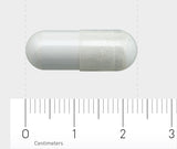 Das Bild zeigt eine weiße Kapsel, die horizontal auf einem Lineal liegt. Das Lineal hat eine Skala in Zentimetern und Millimetern. Die Kapsel ist etwa 2 Zentimeter lang und hat eine glatte Oberfläche.