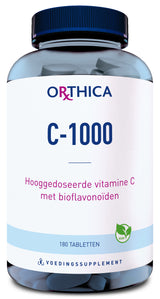 Ein blaues Glas mit schwarzem Deckel, das 180 Tabletten enthält. Auf dem Etikett steht 'Orthica C-1000', 'Hooggedoseerde vitamine C met bioflavonoïden' und 'Vegan'.