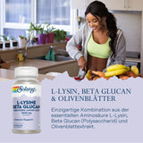 Eine Frau in sportlicher Kleidung schneidet Obst in einer modernen Küche. Im Vordergrund ist eine Flasche mit dem Label "Solaray L-Lysine Beta Glucan" zu sehen. Text beschreibt eine Kombination aus L-Lysin, Beta Glucan und Olivenblätter-Extrakt.