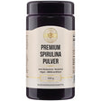 Eine schwarze Plastikdose mit einem Etikett, auf dem "Premium Spirulina Pulver" steht. Das Produkt ist ohne Gentechnik, glutenfrei, vegan und GRAS-zertifiziert. Die Dose enthält 250 g Nahrungsergänzungsmittel.