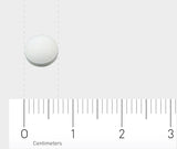 Eine weiße Tablette liegt auf einem Lineal, das in Zentimetern skaliert ist. Die Tablette befindet sich zwischen den Markierungen 0 und 1 Zentimeter. Der Hintergrund ist hellgrau.