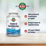 Das Bild zeigt eine Flasche mit Vitamin B5 Pantothensäure von der Marke KAL. Die Flasche ist weiß mit einem blauen Etikett, auf dem "Vitamin B5 Pantothensäure 1000 mg" steht. Daneben sind drei Checklisten-Punkte: "1000 mg Vitamin B5 Pantothensäure pro Tablette", "Verzögerte Abgabe für Langzeitversorgung" und "100 vegane Tabletten pro Packung". Im Hintergrund ist ein verschwommener grüner und weißer Hintergrund zu sehen. Oben auf der Flasche steht "Since 1932" und das KAL-Logo ist zu sehen.