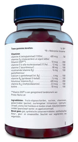 Das Bild zeigt eine Nahaufnahme eines transparenten Kunststoffbehälters mit einem blauen Schraubverschluss, der mit Gummibärchen gefüllt ist. Auf dem Etikett sind Informationen zu den enthaltenen Vitaminen und Zutaten in niederländischer Sprache aufgedruckt. Es werden verschiedene Vitamine wie A, D3, E, C, B3, B5, B6, B11, B12 und Biotin aufgelistet, sowie deren Mengen und der Prozentsatz der Referenzaufnahme. Der Behälter steht aufrecht und ist teilweise durchsichtig, sodass die roten Gummibärchen im Inner