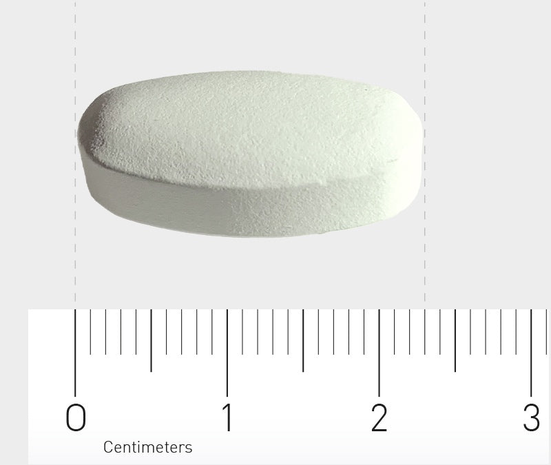 Das Bild zeigt eine weiße, ovale Tablette, die auf einem Lineal liegt. Das Lineal zeigt eine Länge von etwa 2 Zentimetern. Der Hintergrund ist neutral gehalten, um die Tablette und das Lineal hervorzuheben.