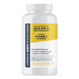 Eine weiße Flasche mit einem gelben Etikett, das "Enhanced with Rose Hips & Grape Seed Extract" und "500mg Vitamin C per Serving" zeigt. Empfohlene Anwendung: 1-2 Kapseln täglich. Warnhinweise und Kontaktinformationen sind ebenfalls enthalten.