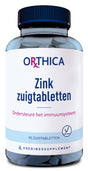Eine Flasche mit blauen Zink-Zuigtabletten von Orthica. Auf dem Etikett steht: 'Zink zuigtabletten, Ondersteunt het immuunsysteem, 90 zuigtabletten, Voedingssupplement'. Das Etikett ist hauptsächlich weiß mit blauen und violetten Akzenten. Die Flasche hat einen dunkelblauen Deckel.