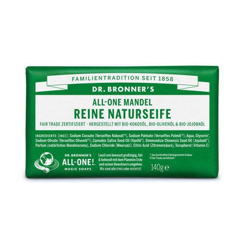 Eine rechteckige Verpackung mit grünem Hintergrund zeigt "Dr. Bronner's All-One Mandel Reine Naturseife". Die Verpackung ist mit Informationen zu Inhaltsstoffen und Zertifizierungen bedruckt. Die Seife ist fair trade zertifiziert und aus Bio-Zutaten hergestellt.
