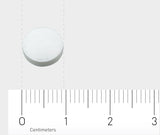 Das Bild zeigt eine einzelne weiße Tablette auf einem hellgrauen Hintergrund. Unterhalb der Tablette befindet sich ein Lineal, das in Zentimetern skaliert ist, von 0 bis 3 cm, um die Größe der Tablette zu verdeutlichen.