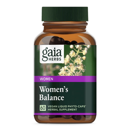 Eine braune Flasche mit einem grünen Deckel, auf der ein Etikett mit der Aufschrift 'gaia HERBS', 'WOMEN', 'Women's Balance', '60 VEGAN LIQUID PHYTO-CAPS', 'HERBAL SUPPLEMENT' zu sehen ist. Im Hintergrund sind weiße Blüten abgebildet.