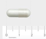 Eine weiße Kapsel liegt horizontal auf einem Lineal, das in Zentimetern skaliert ist. Die Kapsel ist etwa 2 Zentimeter lang. Der Hintergrund ist grau.