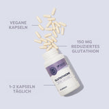 Ein weißes Fläschchen mit lila Etikett liegt auf einer hellen Oberfläche. Aus dem geöffneten Fläschchen fallen weiße Kapseln heraus. Auf dem Etikett steht 'GLUTATHIONE'. Neben dem Fläschchen sind die Begriffe 'VEGANE KAPSELN', '150 MG REDUZIERTES GLUTATHION' und '1-2 KAPSELN TÄGLICH' zu lesen.