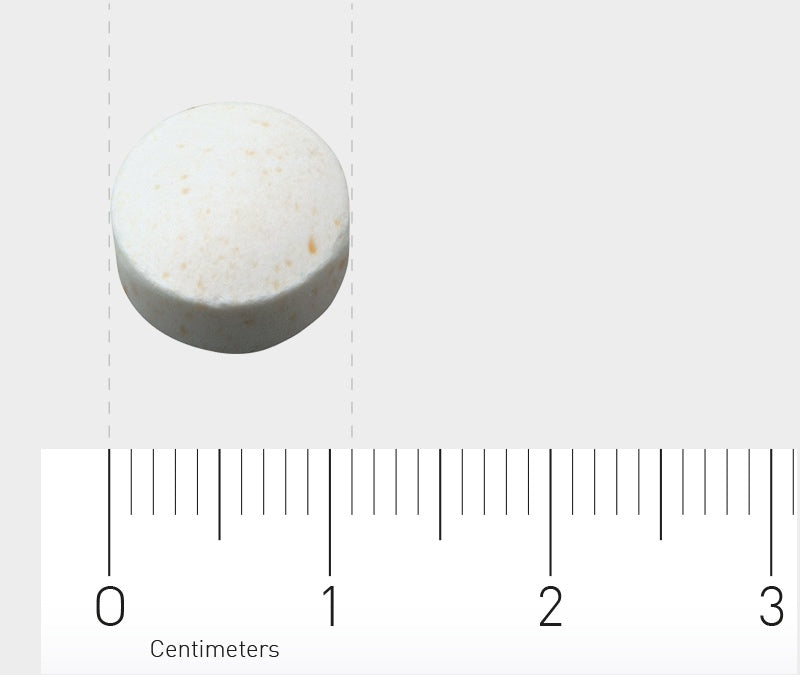 Das Bild zeigt eine weiße Tablette auf einem Lineal mit Zentimetermarkierungen. Die Tablette liegt auf einer grauen Oberfläche und ist in der Mitte des Bildes platziert. Das Lineal zeigt eine Skala von 0 bis 3 Zentimetern.