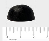 Das Bild zeigt ein schwarzes, halbkugelförmiges Objekt, das auf einer weißen Oberfläche liegt. Vor dem Objekt befindet sich ein Lineal mit Zentimeterangaben. Das Objekt ist etwa 2 Zentimeter breit. Der Hintergrund ist neutral grau.