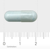 Das Bild zeigt eine weiße Kapsel auf einem Lineal mit Zentimeterangaben. Die Kapsel liegt horizontal und misst etwa 2 Zentimeter. Der Hintergrund ist neutral, sodass der Fokus auf der Kapsel liegt.