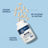 Das Bild zeigt eine weiße Flasche mit der Aufschrift 'MSM with Silica + Calcium', die auf einem blauen Hintergrund liegt. Um die Flasche herum sind mehrere vegane Kapseln verstreut. Auf der Flasche steht '120 Capsules' und 'Dietary Supplement'. Auf dem Bild sind außerdem die Texte 'Vegane Kapseln', 'Mit Silizium & Calcium' und '1 Kapsel täglich' zu sehen.