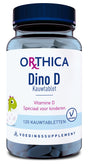 Eine Plastikflasche mit blauen Deckel und blau-weißer Etikettierung. Auf dem Etikett steht "Orthica Dino D Kauwtablet" und "Vitamine D Speciaal voor kinderen". Ein grüner Dinosaurier ist abgebildet. Die Flasche enthält 120 Kautabletten.