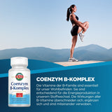 Frau in Sportkleidung macht Dehnübung auf Berggipfel. Vorne links Coenzym B-Komplex Flasche. Text beschreibt Nutzen von B-Vitaminen.