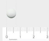 Eine weiße Tablette liegt auf einer grauen Oberfläche. Darunter ist ein Lineal mit Zentimeter-Einteilung zu sehen, das die Größe der Tablette verdeutlicht.