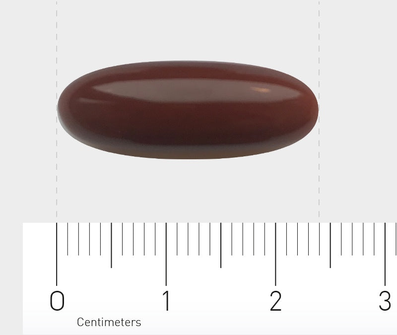 Eine braune, ovale Tablette liegt auf einem weißen Hintergrund. Unter der Tablette befindet sich ein Lineal mit Zentimeterangaben, das die Größe der Tablette zeigt.