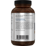 Eine weiße Plastikflasche mit der Aufschrift 'Selen 100' von American Biologics. Die Flasche enthält Nahrungsergänzungsmittel mit Selen, 90 Kapseln. Auf dem Etikett steht 'vegan' und 'non-GMO'. Vor der Flasche liegen drei weiße Kapseln.