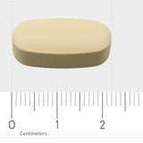Das Bild zeigt eine ovale, beige Tablette, die auf einem Lineal liegt. Das Lineal misst in Zentimetern und zeigt, dass die Tablette etwa 2 cm lang ist. Der Hintergrund ist grau.