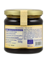 Ein Glas Waldhonig mit Etikett in Deutsch und Französisch, 500g, Herkunft Italien, Bio-Zertifikat, Qualitätsgarantie, geeignet für Säuglinge ab 12 Monaten.
