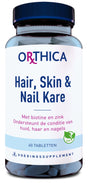 Das Bild zeigt eine blaue Flasche mit einem Etikett der Marke Orthica. Auf dem Etikett steht 'Hair, Skin & Nail Kare'. Es enthält 60 Tabletten und ist ein Nahrungsergänzungsmittel mit Biotin und Zink. Ein grünes Blatt-Symbol zeigt an, dass es vegan ist.