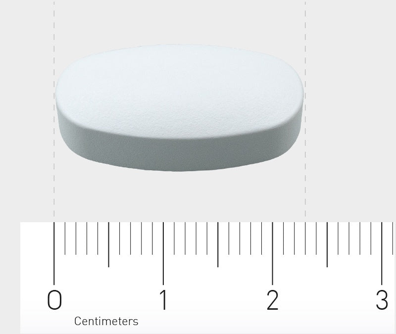 Eine weiße, ovale Tablette liegt auf einer grauen Oberfläche. Darunter befindet sich ein Lineal, das die Größe der Tablette in Zentimetern anzeigt. Die Tablette ist etwa 2 cm lang. Das Bild hat einen neutralen Hintergrund.
