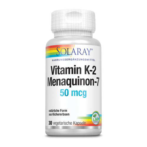 Eine weiße Plastikflasche mit einem farbigen Etikett, das "SOLARAY Vitamin K-2 Menaquinon-7 50 mcg" anzeigt. Die Flasche enthält 30 vegetarische Kapseln und ist als Nahrungsergänzungsmittel aus natürlicher Form von Kichererbsen gekennzeichnet. Ein Lab Verified-Siegel befindet sich auf dem Etikett.