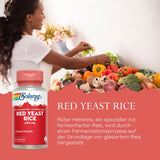 Eine Frau bereitet in einer Küche frisches Gemüse wie Tomaten, Paprika und Brokkoli zu. Im Vordergrund ist eine Verpackung von Solaray Red Yeast Rice Nahrungsergänzungsmittel zu sehen. Der Hintergrund ist hell und mit Blumen dekoriert.