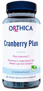 Das Bild zeigt eine Produktverpackung von Orthica Cranberry Plus. Es handelt sich um eine Flasche mit einem blauen Deckel und einem weißen Etikett, auf dem der Produktname, die Funktion des Produkts (Plus Vitamin C), und die Anzahl der Kapseln (60 Vegacapsules) angegeben sind. Das Etikett enthält auch einen Hinweis auf die Unterstützung des Immunsystems durch Vitamin C und ein veganes Logo. Die Flasche ist durchsichtig, sodass die blauen Kapseln im Inneren sichtbar sind.