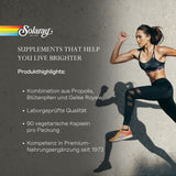 Das Bild zeigt eine sportliche Frau in Sportbekleidung, die in einer dynamischen Pose vor einer grauen Wand läuft. Links im Bild sind Informationen zu einem Nahrungsergänzungsmittel von Solaray zu sehen, inklusive Produktvorteilen und Markenlogo.