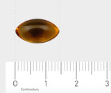 Eine gelbe, ovale Gelkapsel liegt auf einer weißen Oberfläche mit einem Lineal darunter. Das Lineal zeigt Zentimetermaße an, wobei die Kapsel etwa 2 cm lang ist.