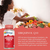 Eine Frau bereitet in einer hellen Küche frisches Gemüse zu. Auf der Arbeitsfläche liegen Tomaten, Paprika und Brokkoli. Im Vordergrund ist eine Flasche Solaray Ubiquinol CoQ-10 Nahrungsergänzungsmittel zu sehen. Der Hintergrund ist weiß und mit Blumen dekoriert.