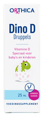 Eine Verpackung des Nahrungsergänzungsmittels 'Dino D Druppels' von Orthica. Auf der Vorderseite steht 'Vitamine D Speciaal voor baby's en kinderen'. Ein grüner Dinosaurier schlüpft aus einem Ei. Das Produkt ist vegetarisch und zuckerfrei.