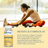 Eine Frau in Sportkleidung dehnt sich auf einem Boden in einem hellen Raum. Sie trägt ein weißes Oberteil und orangefarbene Leggings. Neben ihr ist eine Verpackung von Solaray Methyl B-Complex 50 abgebildet. Auf der Verpackung stehen Informationen zu den Inhaltsstoffen und Vorteilen des Produkts, wie Energieunterstützung und Immunsystemstärkung. Die Szene wirkt motivierend und gesundheitsbewusst.