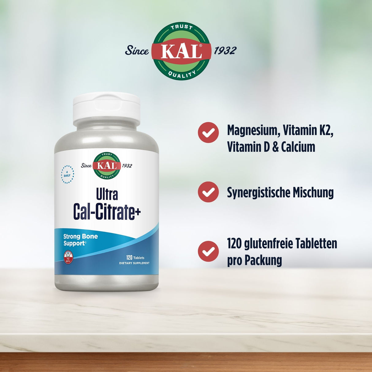 Das Bild zeigt eine Flasche des Nahrungsergänzungsmittels 'KAL Ultra Cal-Citrate+' auf einem Tisch. Auf der Flasche steht 'Strong Bone Support'. Rechts sind drei Textblöcke mit Häkchen: 'Magnesium, Vitamin K2, Vitamin D & Calcium', 'Synergistische Mischung', '120 glutenfreie Tabletten pro Packung'. Im Hintergrund ist das KAL-Logo mit 'Since 1932' zu sehen. Der Hintergrund ist unscharf und hell.