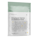 Die Abbildung zeigt eine Verpackung von "Himalayan Tartary Buckwheat Flour" der Marke Big Bold Health. Die Verpackung ist weiß mit einem grünen oberen Rand. Auf der Vorderseite steht der Produktname in großer Schrift, darunter befindet sich ein Text, der die gesundheitlichen Vorteile des Produkts beschreibt. Es wird hervorgehoben, dass das Mehl aus einem alten Pflanzenstamm stammt, der in extremen Klimazonen wächst und starke immunstärkende Eigenschaften besitzt. Am unteren Rand der Verpackung sind die Begr